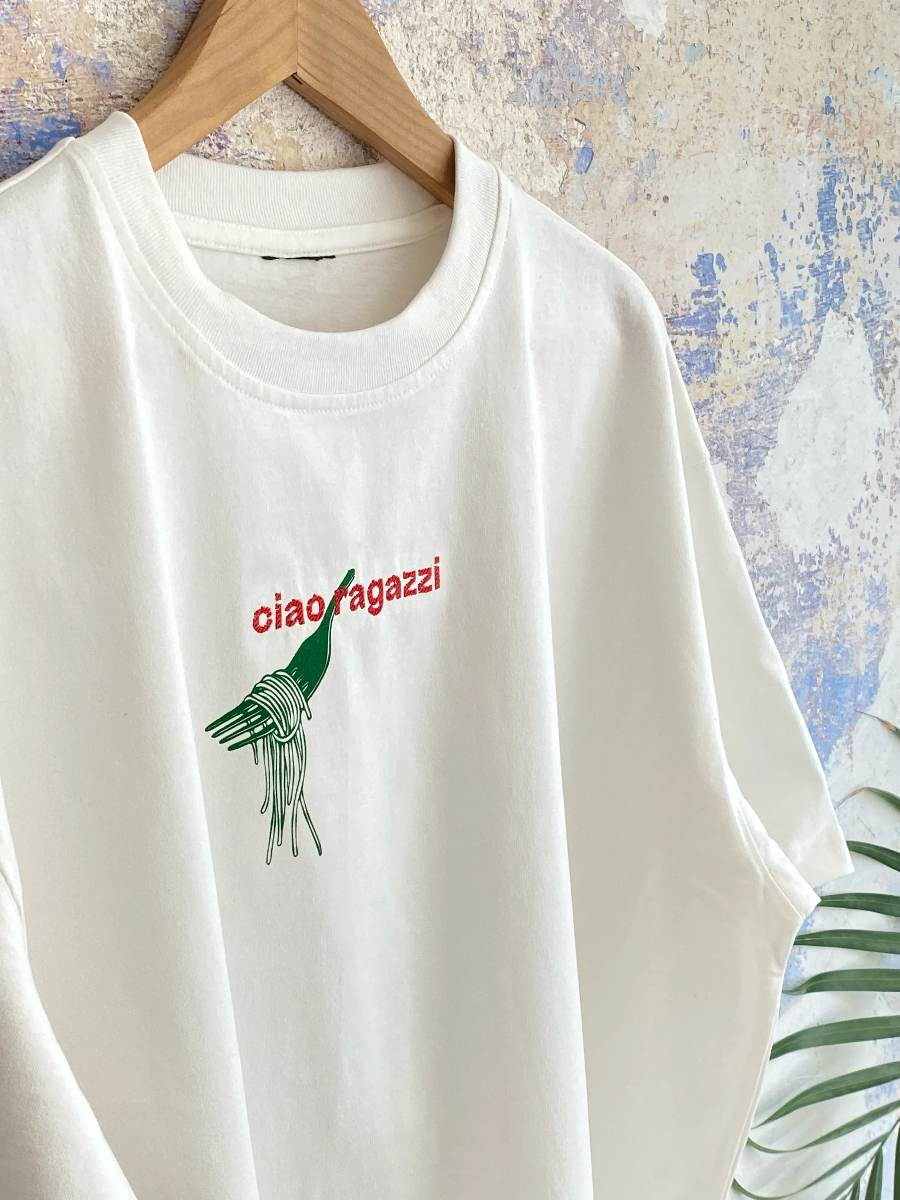 T-Shirt mit typografischem Schriftzug „ciao ragazzi“ und Pasta-Motiv als Kombination aus Stickerei und Siebdruck