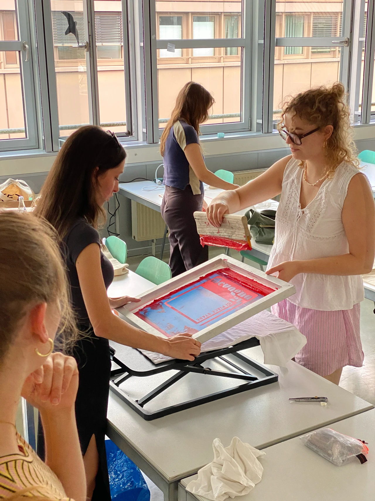 Siebdruckprozess im Workshop: Farbe wird mit Rakel auf T-Shirt gedruckt