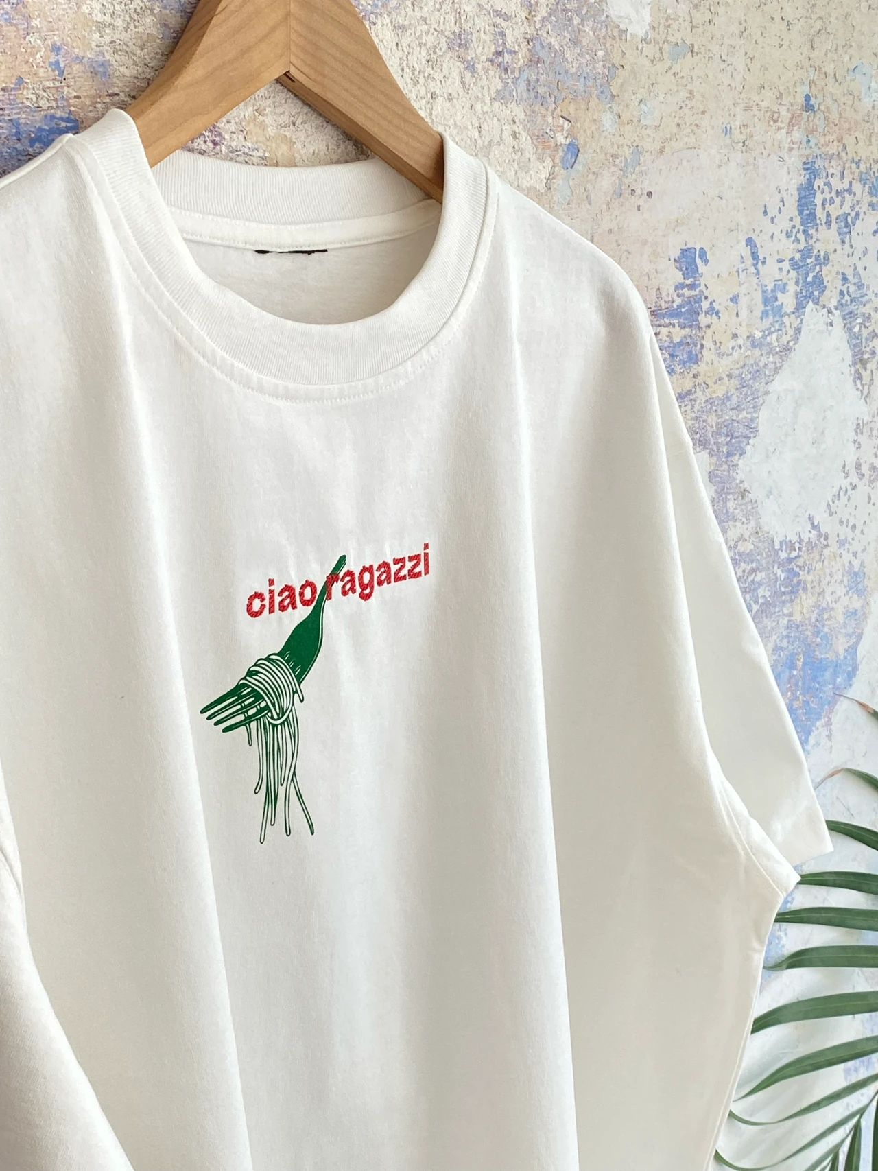 T-Shirt mit typografischem Schriftzug „ciao ragazzi“ und Pasta-Motiv als Kombination aus Stickerei und Siebdruck